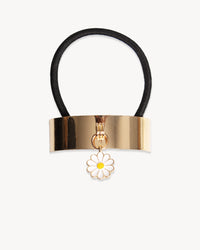 Hair tie with gold clasp and flower charm on a white background