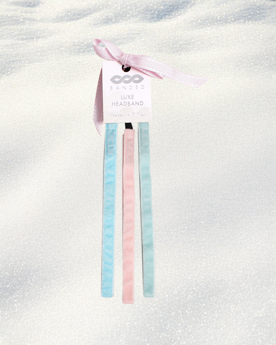 Pastel blue and pink headbands on a white background with a visible brand tag.