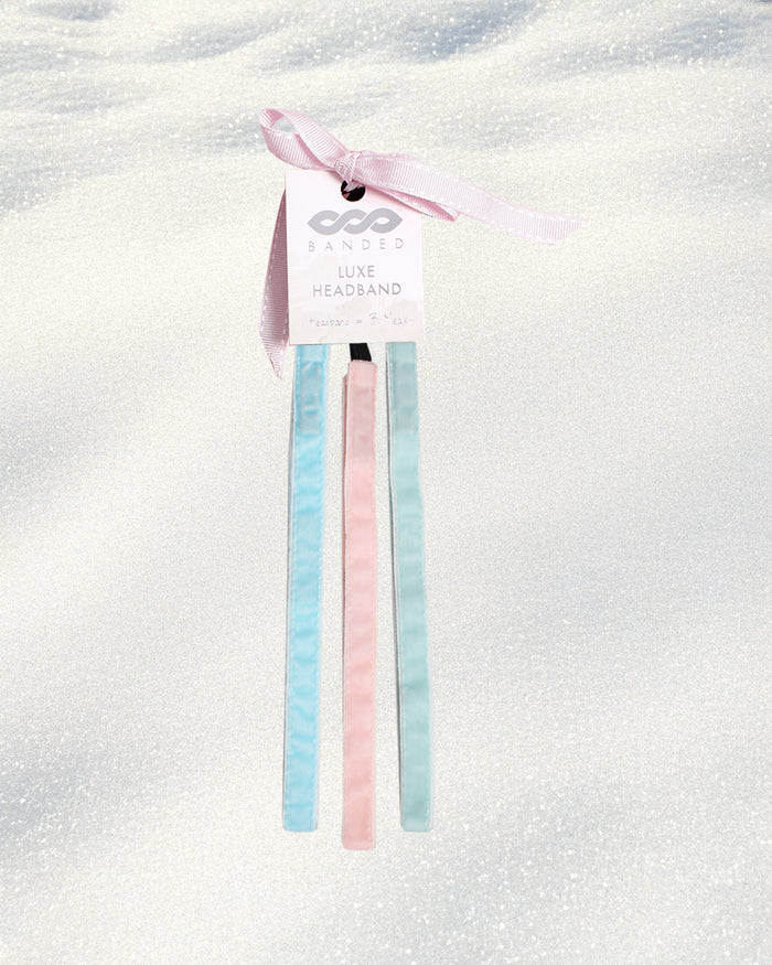 Pastel blue and pink headbands on a white background with a visible brand tag.