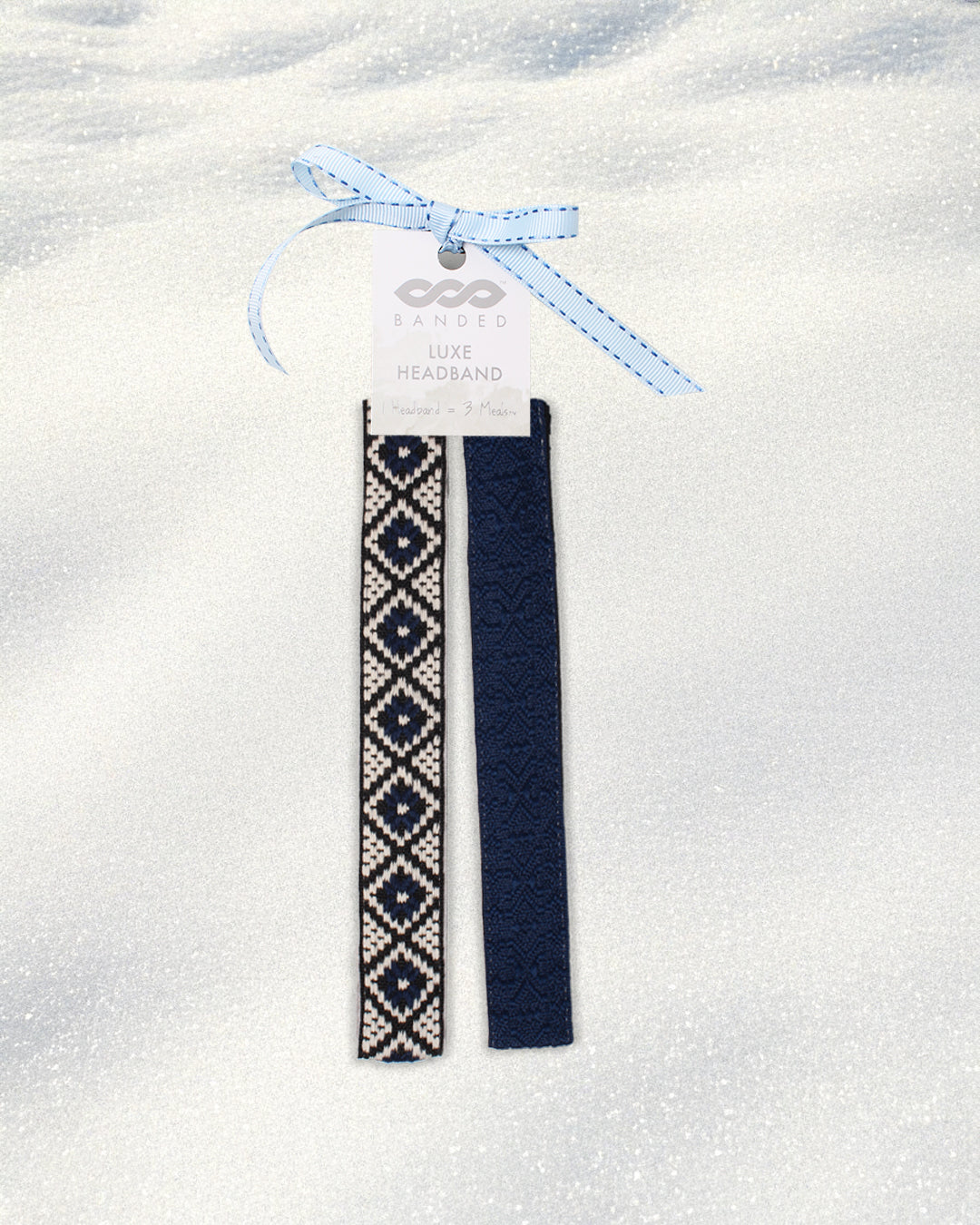 Two navy blue headbands with white patterns on a white background, tied together with a blue ribbon.