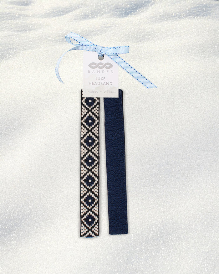Two navy blue headbands with white patterns on a white background, tied together with a blue ribbon.