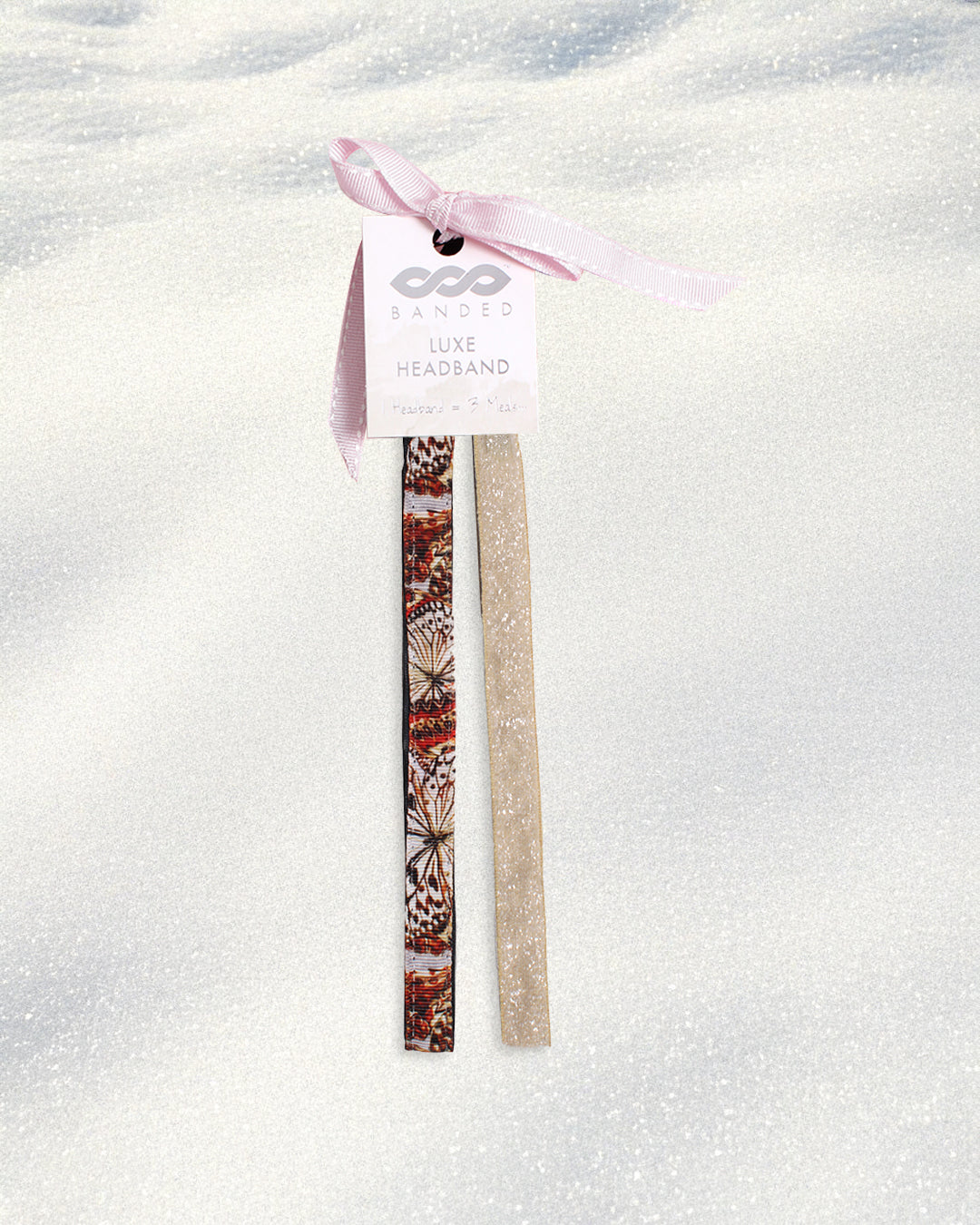 Two headbands, one with a butterfly pattern and one plain beige, on a white background.