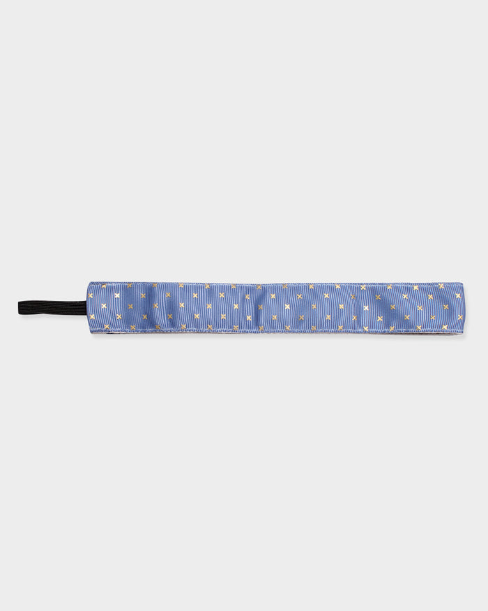 Blue headband with gold x's on a white background
